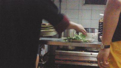 7月23日，漢麗軒烤肉超市昌平店，服務員將幾盤顧客剩菜（左手中疊在一起的是幾盤肉，其右手正整理韭菜）端回后廚，進行整理后準備再送往餐廳自助取餐區供顧客食用。